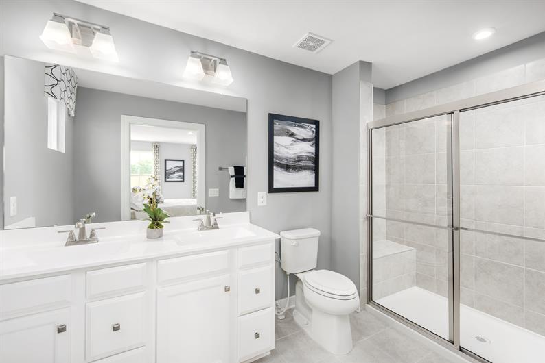 ENJOY AN EN SUITE WITH RELAXING SEATED SHOWER AND SPACIOUS WALK-IN CLOSET 
